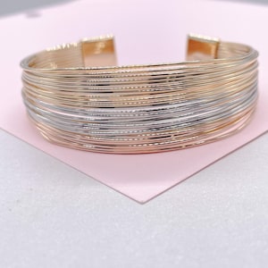 Op de afbeelding: Een meerrijige armband van goud en zilver. De armband is gemaakt van dunne, verweven draden.