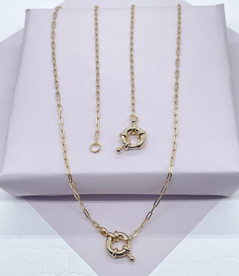 May include: A gold chain necklace with a toggle clasp. The chain is made of small, linked ovals.