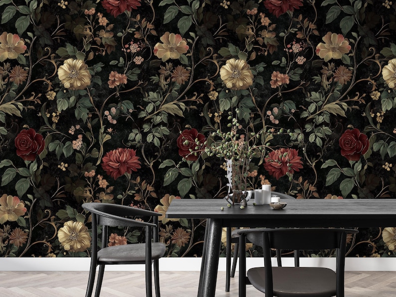 Puede incluir: Un papel tapiz floral en blanco y negro con una est&eacute;tica vintage oscura. El papel tapiz presenta un patr&oacute;n repetitivo de flores y hojas rojas, amarillas y verdes. El papel tapiz se muestra en un ambiente de comedor con una mesa y sillas negras.