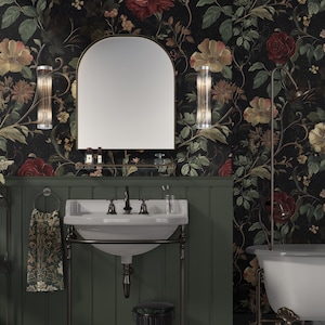 Puede incluir: Un ba&ntilde;o con una pared de azulejos verdes y un papel tapiz floral. Un lavabo de porcelana blanca con un grifo cromado est&aacute; sobre un soporte de metal negro. Un toallero de metal negro con una toalla de estampado floral est&aacute; a la izquierda. Una ba&ntilde;era blanca est&aacute; a la derecha.