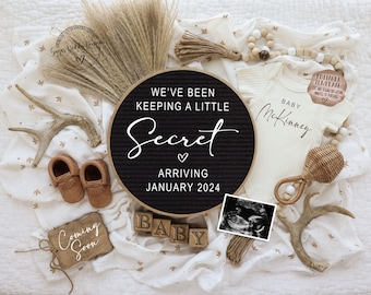 May include: A black letter board with the text "We've been keeping a little secret arriving January 2024". The letter board is surrounded by baby items, including a white onesie with the text "Baby McKinney", a pair of brown moccasins, a wooden sign that says "Coming Soon", and a wooden block that says "Baby".
