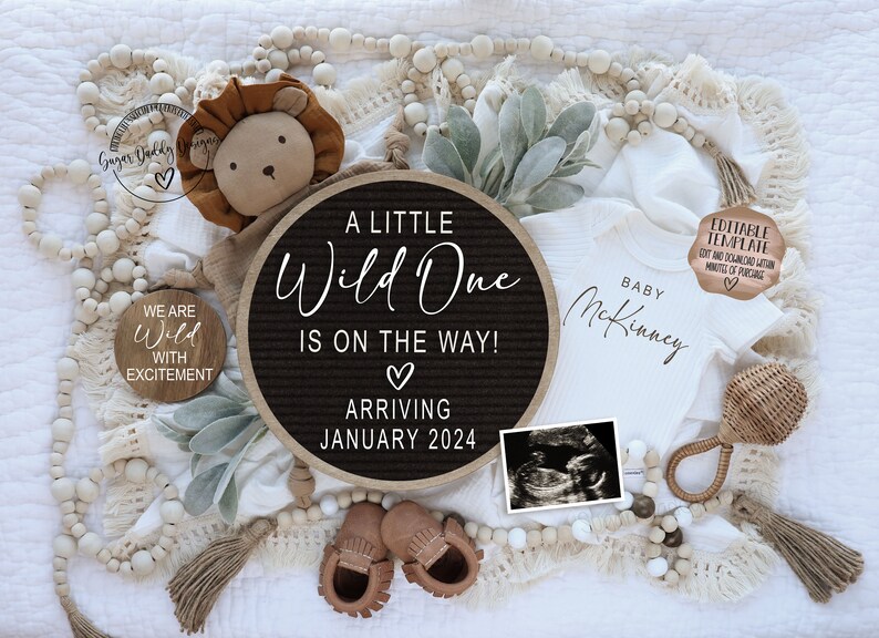 Peut inclure: Un tableau d'affichage noir et blanc avec le texte "A Little Wild One Is On The Way! Arriving January 2024". Le tableau est entour&eacute; d'une couverture blanche, d'un lion en peluche, d'une grenouill&egrave;re pour b&eacute;b&eacute;, d'un hochet en bois et d'une petite pancarte en bois qui dit "We Are Wild With Excitement".