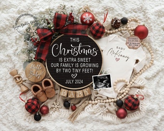 May include: A Christmas-themed baby announcement with a black and white sign that reads "This Christmas is extra sweet our family is growing by two tiny feet! July 2024". There is a white onesie with the text "Baby McKinney" and a red heart. There are also wooden blocks that spell out "BABY" and a small wooden sign that says "Hello Baby!"