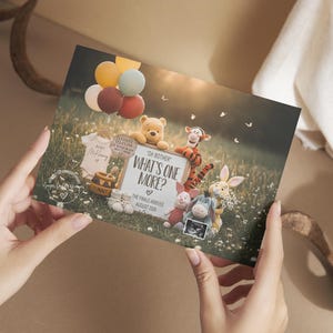 May include: A card with a meadow scene featuring Winnie the Pooh characters, balloons, and the text "What's One More?" announcing a new baby. The card includes a sonogram and baby clothes.