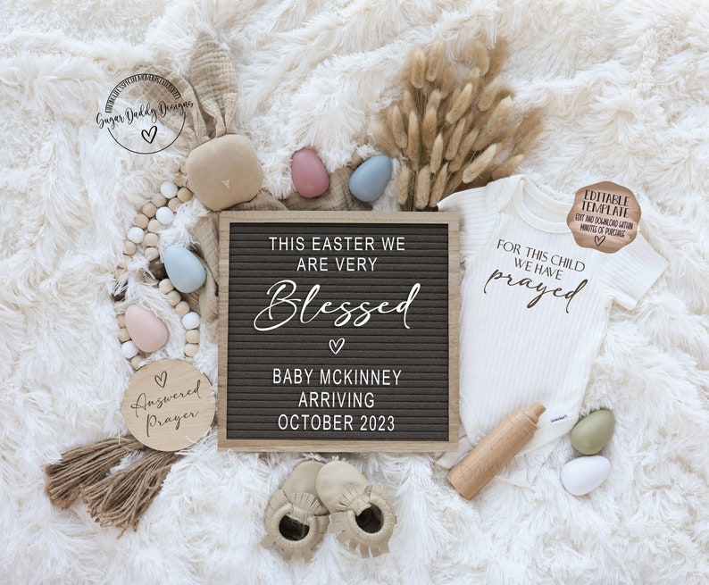 May include: A white onesie with the text "For this child we have prayed" on it. A letter board with the text "This Easter we are very Blessed. Baby McKinney Arriving October 2023". A wooden sign with the text "Answered Prayer".