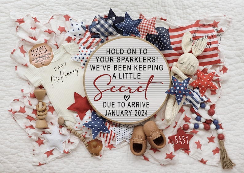 May include: A white baby onesie with the text "BABY McKinney" on it, surrounded by red, white, and blue stars, a wooden rattle, and a sign that reads "Hold on to your sparklers! We've been keeping a little secret. Due to arrive January 2024."