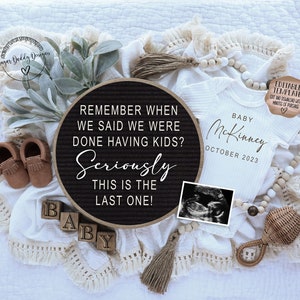 May include: A black letter board with the text "Remember when we said we were done having kids? Seriously this is the last one!"  A white onesie with the text "Baby McKinney October 2023" and a small ultrasound image are also in the image.