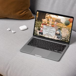 May include: A laptop displays a pregnancy announcement with Winnie the Pooh characters. The announcement reads "We are excited to say our little Hunny is on the way, arriving October 2024." The screen also shows a sonogram and baby clothes.