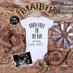 Könnte beinhalten: Ein weißer Strampler mit dem Text "Farm Help On The Way" und dem Datum "June 2023". Der Strampler ist von rustikalem Dekor umgeben, darunter ein Holzschild mit der Aufschrift "Baby McKinney", eine kleine Holzwindmühle und ein Paar braune Babyschuhe.