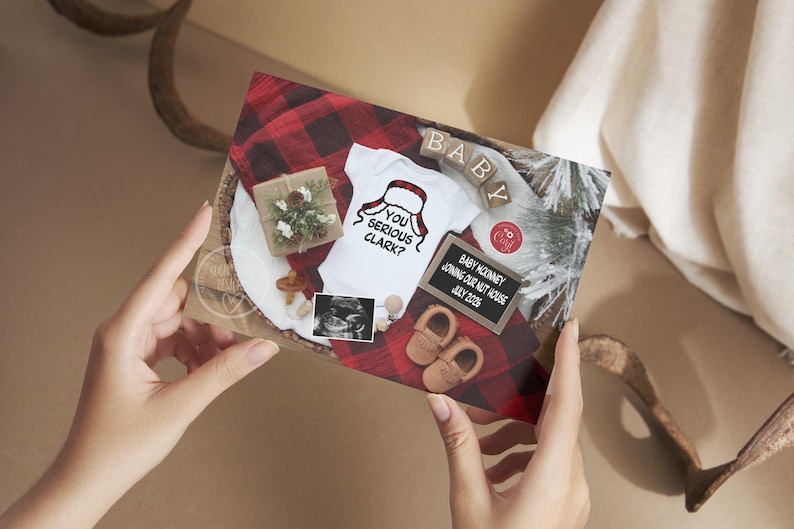 May include: A pregnancy announcement card with a white onesie featuring a Santa hat design and the text "YOU SERIOUS CLARK?". The card includes baby shoes, a sonogram, and a small gift box on a red and black plaid background.
