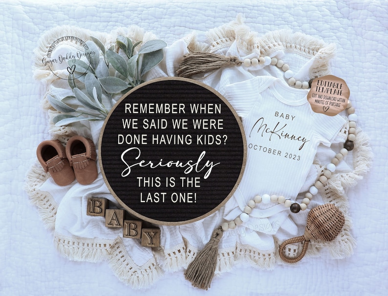 May include: A black letter board with the text "Remember when we said we were done having kids? Seriously this is the last one!"  A white onesie with the text "Baby McKinney October 2023" is next to the letter board.  There are brown moccasins, wooden blocks that spell "baby", and a wooden rattle.