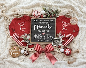May include: A Christmas-themed twin pregnancy announcement featuring red and white striped candy canes, a red and white striped bow, a wooden sign that reads "Sometimes when you pray for a miracle you get two McKinney Twins August 2024", and two red onesies with the text "Prayed for one" and "Blessed with two".