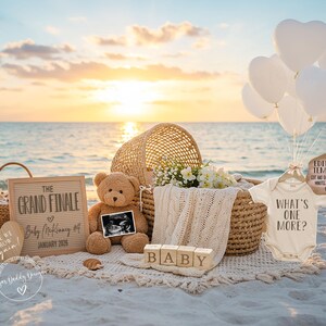 Puede incluir: Una escena de playa con art&iacute;culos de anuncio de beb&eacute;. Incluye un oso de peluche, una imagen de ultrasonido, una pizarra con texto, un body que dice "What's One More?", globos blancos en forma de coraz&oacute;n y una cesta de mimbre. El texto en la pizarra dice "The Grand Finale".