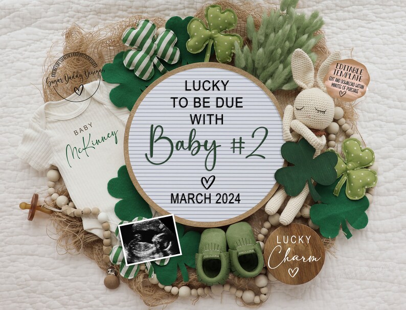 Puede incluir: Un body blanco con el texto "BABY McKinney" en letras verdes, una pizarra blanca con el texto "LUCKY TO BE DUE WITH Baby #2  ♡ MARCH 2024", un conejito blanco de crochet, un letrero de madera con el texto "LUCKY Charm ♡", y decoraciones de tr&eacute;bol verde.