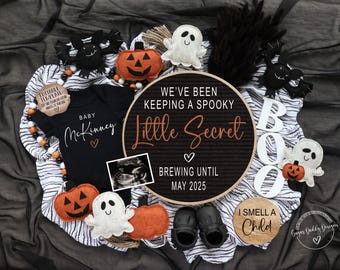 May include: A Halloween-themed baby announcement with a black and white striped blanket, a black onesie with the text "Baby McKinney", a round sign with the text "We've been keeping a spooky little secret brewing until May 2025", a white ghost, a pumpkin, and a white sign with the text "I smell a child".