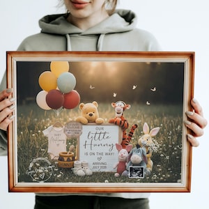 May include: A framed image featuring Winnie the Pooh characters, balloons, and baby items. The sign reads "Our little Hunny is on the way!" with an arrival date of July 2028. The image is held by a person.