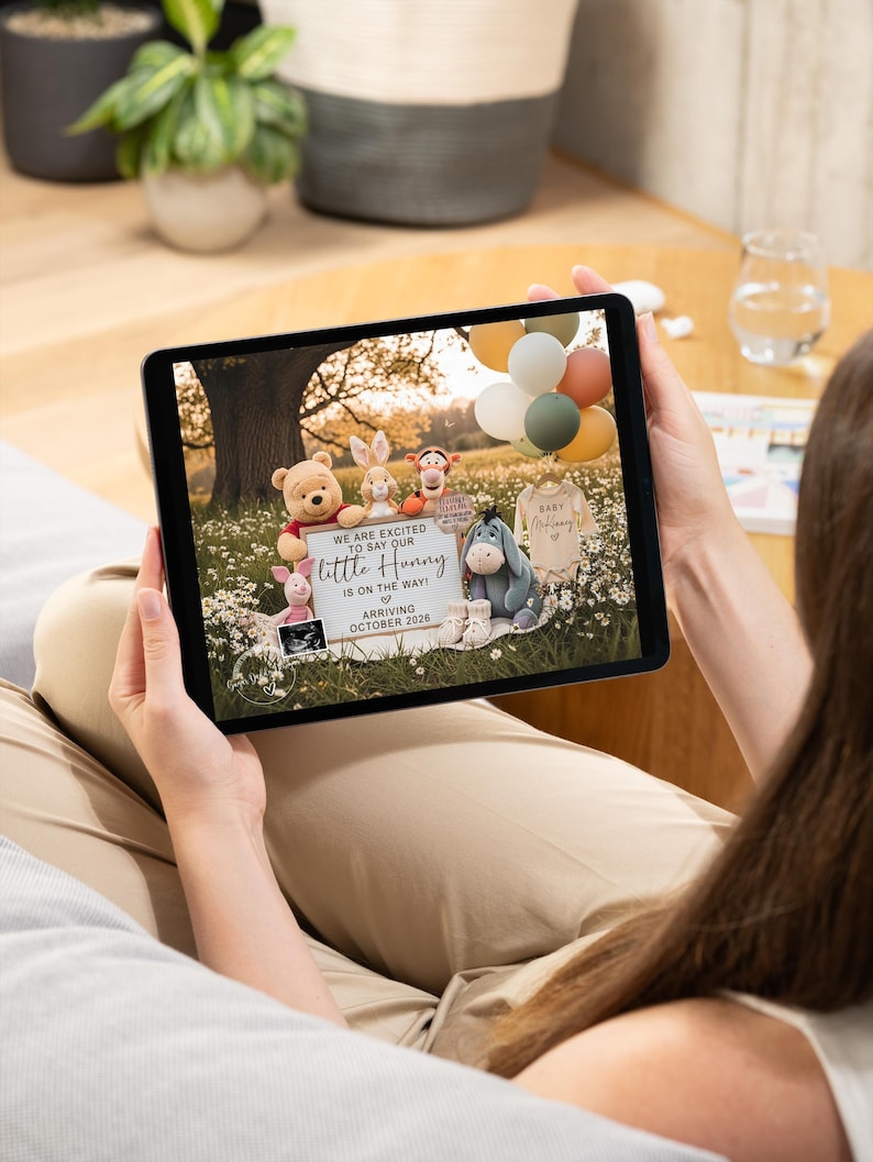 May include: A tablet displays a baby announcement with Winnie the Pooh characters. The announcement includes the text "We are excited to say our little Hunny is on the way! Arriving October 2026."