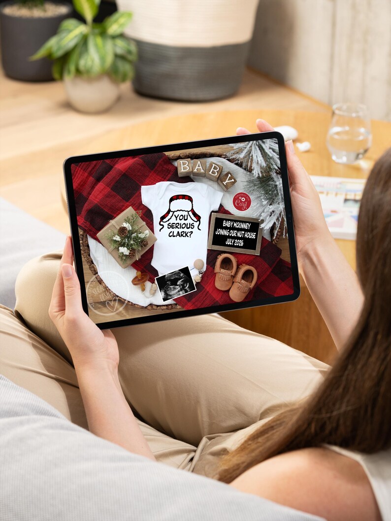 May include: A tablet displays a pregnancy announcement with a white onesie that says "You Serious Clark?" and a Santa hat graphic. The announcement includes baby shoes, a sonogram, and the text "Baby McKinney Joining Our Nut House July 2026."