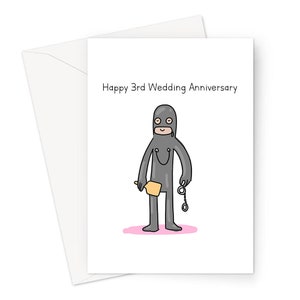May include: A humorous greeting card with a cartoon illustration of a person in a black leather suit, mask, and handcuffs. The text on the card reads "Happy 3rd Wedding Anniversary".