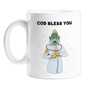 May include: White ceramic mug featuring a cartoon fish dressed as a doctor, complete with a stethoscope and a crown. The fish is holding its hands together in a prayer position. The text "COD BLESS YOU" is printed on the mug.