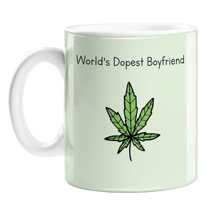 May include: White ceramic mug with a green cannabis leaf and the text "World's Dopest Boyfriend" printed on it.