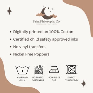 May include: A white graphic with black text and icons outlining the care instructions for a 100% cotton product. The text reads "Digitally printed on 100% Cotton", "Certified child safety approved inks", "No vinyl transfers", and "Nickel Free Poppers". The icons show a washing machine with a cold water setting, a crossed-out bottle of fabric softener, an iron with a dot inside, and a crossed-out circle.