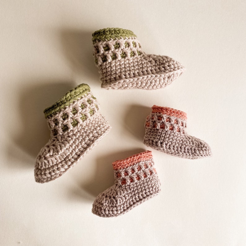 May include: Four crocheted baby booties in different colors. Two are green and two are pink. The booties are made with a textured stitch and have a pointed toe.