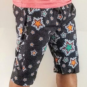 May include: Black shorts with a white and colourful star pattern. The stars have a variety of colours, including orange, green, and red.