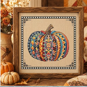 May include: A cross-stitch pattern titled Patchwork Pumpkin 4 by designer Svitlana Hrybach, featuring a pumpkin with colourful, intricate geometric and floral patterns in shades of blue, orange, red, and yellow, framed in a square wooden border.