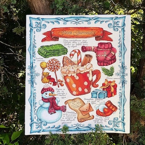 May include: A cross-stitch illustration featuring a cozy winter theme. It includes a red banner with text, a snowman, a mug of hot cocoa, gifts, and other winter-themed items. The border is blue with snowflake designs.