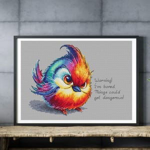 May include: A colorful, cartoon-style bird with a red, orange, yellow, blue, and purple plumage. The bird has a grumpy expression and is saying "Warning! I'm bored. Things could get dangerous!"