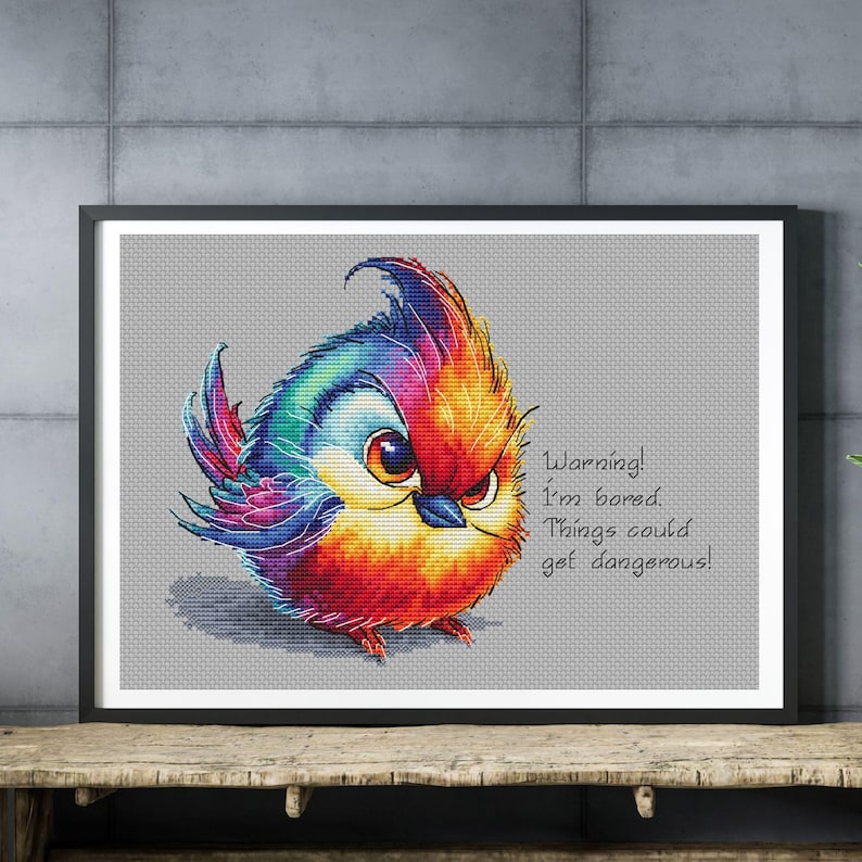 May include: A colorful, cartoon-style bird with a red, orange, yellow, blue, and purple plumage. The bird has a grumpy expression and is saying "Warning! I'm bored. Things could get dangerous!"