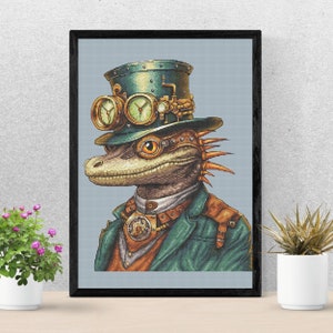 Peut inclure: Broderie encadrée représentant une créature ressemblant à un lézard, vêtue d'un style steampunk. Elle porte un chapeau haut de forme vert avec des lunettes, une veste verte et un collier de bronze. Fond bleu clair.