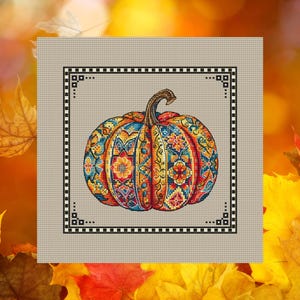 May include: A cross-stitch design of a pumpkin with a detailed, colourful pattern. The pumpkin features shades of orange, yellow, blue, and red, with a brown stem. The design is framed by a black and white border, set against a neutral background.
