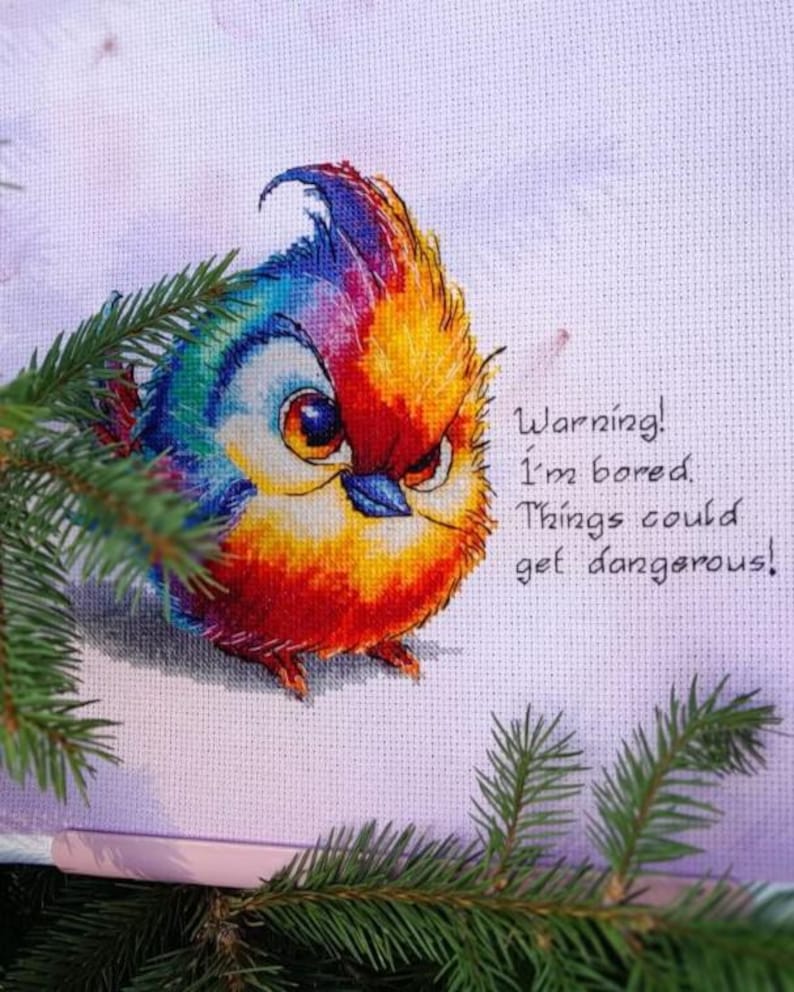 May include: A colorful cross-stitch embroidery of a bird with a warning message: "Warning! I'm bored. Things could get dangerous!"