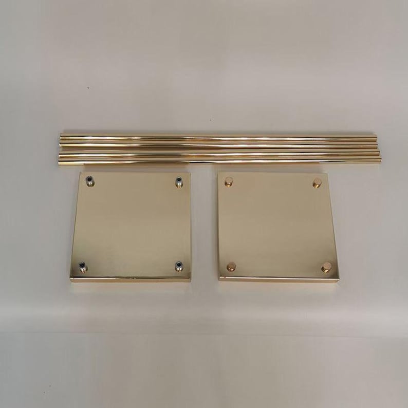 May include: Gold metal cake stand set with four round tiers and four square bases. The stand is disassembled and ready for assembly.
