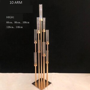 Può includere: Candelabro in metallo dorato a 10 bracci con portacandele in vetro trasparente. Il candelabro è alto 66 cm, 86 cm, 106 cm, 126 cm o 146 cm.