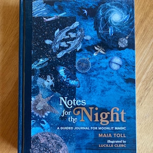 May include: A hardcover journal titled "Notes for the Night" with a blue cover featuring illustrations of fish, butterflies, and celestial elements. The text reads "A guided journal for moonlit magic" by Maia Toll, illustrated by Lucille Clerc.