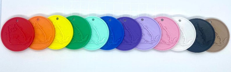 Peut inclure: Un ensemble de dix &eacute;tiquettes rondes en silicone avec un motif d'alligator en relief. Les &eacute;tiquettes sont dans un arc-en-ciel de couleurs, y compris le rouge, l'orange, le jaune, le vert, le bleu, le violet, le rose, le blanc, le noir et le brun.