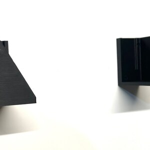 Puede incluir: Dos estanter&iacute;as de pared geom&eacute;tricas negras est&aacute;n montadas en una pared blanca. Las estanter&iacute;as tienen un dise&ntilde;o moderno y minimalista con lados angulados y una forma rectangular. Las estanter&iacute;as est&aacute;n hechas de un material oscuro y s&oacute;lido.