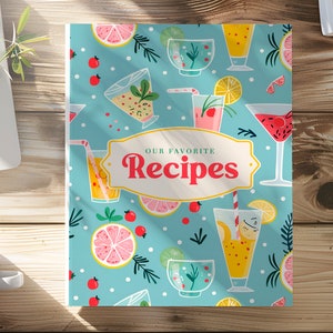 Könnte beinhalten: Ein blauer Rezeptbuchumschlag mit einem bunten Muster aus Cocktails, Zitrusfrüchten und Grün. Der Text "Unsere Lieblingsrezepte" ist in einem weißen Banner dargestellt.
