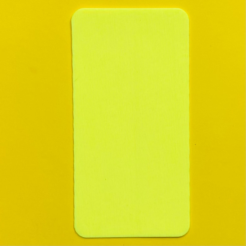 Op de afbeelding: Een rechthoekig, neongeel object met afgeronde hoeken, geplaatst tegen een effen gele achtergrond. De vorm van het object is een lange rechthoek en de kleur is een helder, levendig geel.