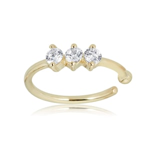 May include: Gold ear cuff with three clear cubic zirconia stones.