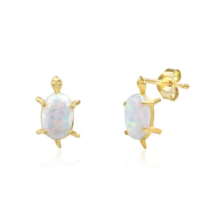 May include: A pair of gold turtle stud earrings with white opal stones.