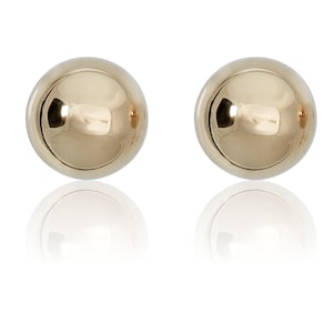 May include: A pair of gold ball stud earrings. The earrings are round and have a smooth, shiny finish.