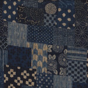 Könnte beinhalten: Ein Patchwork-Stoff mit verschiedenen blauen und beigen Mustern. Das Design umfasst florale, gepunktete und geometrische Motive. Der Stoff wird wahrscheinlich für Quilts oder andere Textilprojekte verwendet.