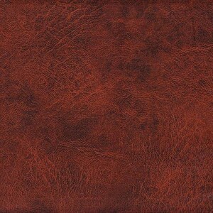 Könnte beinhalten: Nahaufnahme einer strukturierten, rotbraunen Lederoberfläche. Das Leder hat ein marmoriertes Aussehen mit dunkleren Bereichen und sichtbarer Maserung, was auf ein natürliches Material hindeutet. Der Gesamteindruck ist warm und rustikal.