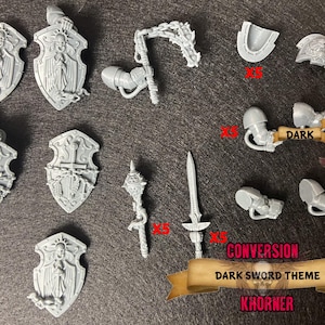 May include: A collection of unpainted, gray plastic miniature conversion parts for a dark sword theme. Includes shields, weapons, and armor pieces. The text on the banner reads "Conversion Dark Sword Theme Khorner".