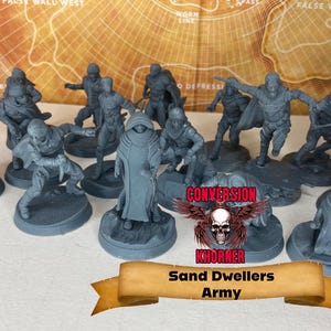 May include: A group of grey miniature figures, possibly for tabletop gaming, showing different characters in action poses. The figures are on circular bases, with a banner reading "Sand Dwellers Army". A map is in the background.
