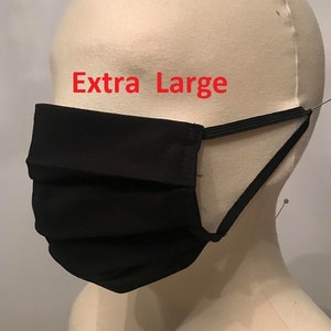 May include: Black face mask with elastic ear loops. The mask is pleated and has the text "Extra Large" printed on it.